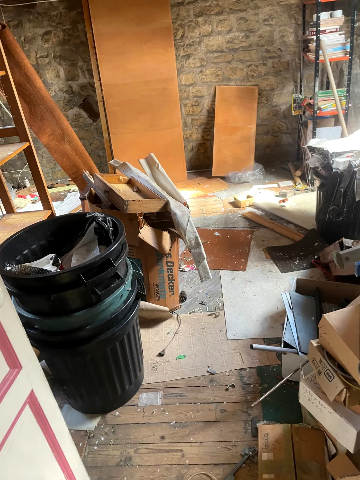 Pièce de combles encombrée, murs en pierre